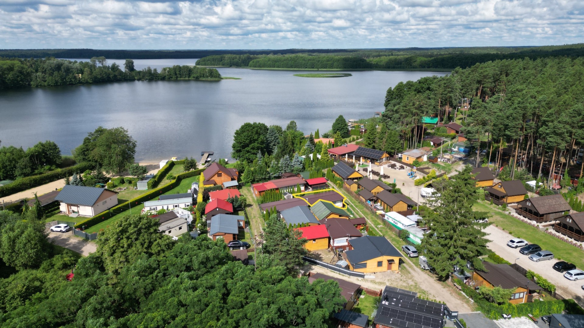 Działka rekreacyjna z domkiem nad jeziorem.